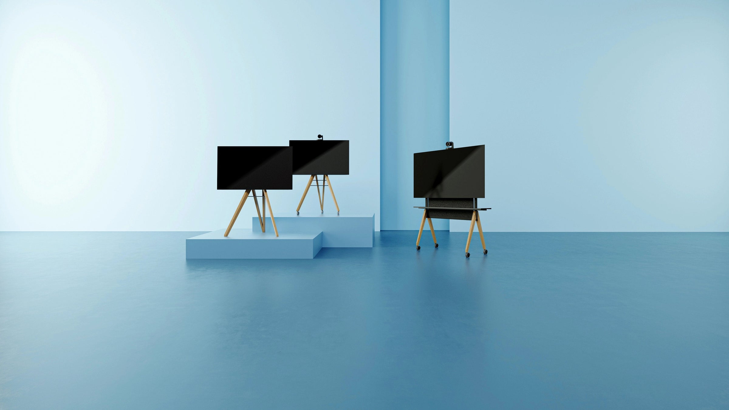 Design TV-Ständer aus Holz stehen aufgereiht auf einer blauen Bühne