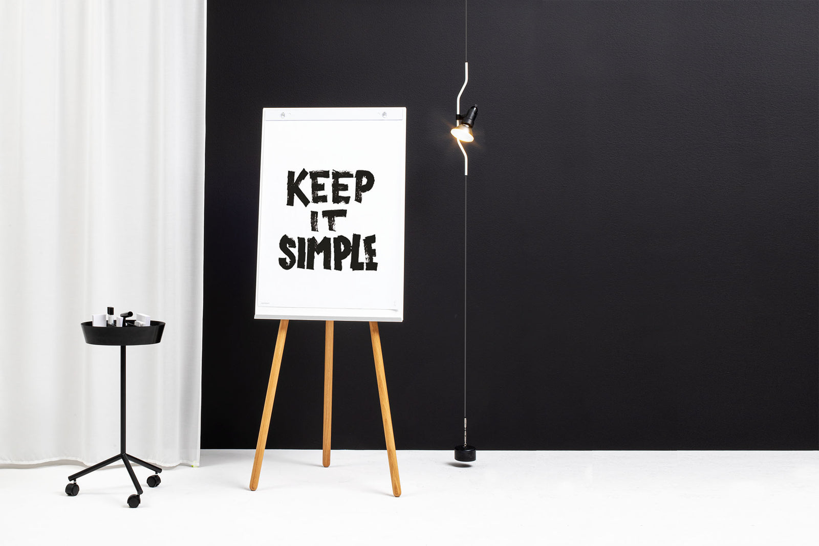 Flipchart Foldable mit weißem Board und Holzbeinen aus Eiche vor schwarzer Wand